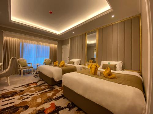 una habitación de hotel con 3 camas con ositos de peluche. en Puteri Wing - Riverside Majestic Hotel, en Kuching