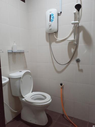 uma casa de banho com um chuveiro e um WC com uma mangueira em Homestay Idaman 2 em Bukit Kayu Hitam