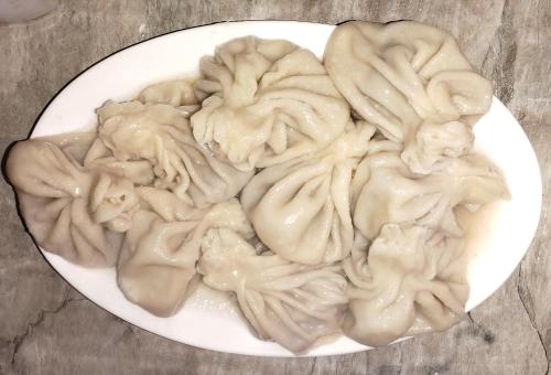 a white plate of dumplings on a table at Vila Latphari in Ushguli in Ushguli