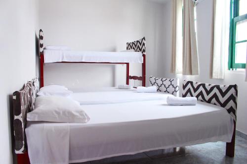 2 beliches num quarto com paredes brancas em Tamboleiro's Hotel Residence em Salvador