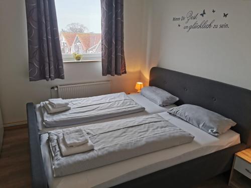 - 2 lits jumeaux dans une chambre avec fenêtre dans l'établissement FeWo Jadeblick - Horumersiel, à Horumersiel