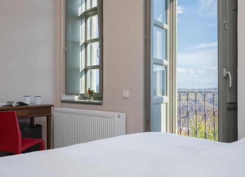 a bedroom with a bed and a window and a desk at KATIKIA ZAGORI in Vitsa