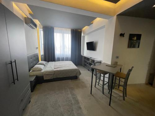 a bedroom with a bed and a table and a desk at Engels apartment in Cluj-Napoca