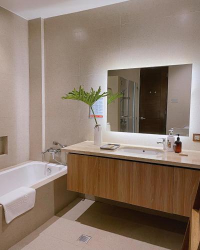 a bathroom with a sink and a tub and a mirror at Gunita Villas in Santo Tomas