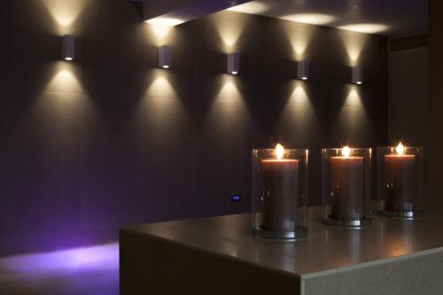 a row of candles on a table with lights at Ego Hotel in Ancona