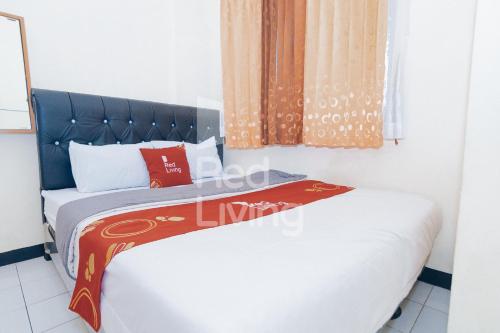 Dos camas en una habitación pequeña con ventana. en RedLiving Apartemen Emerald Hill - SR Rooms Tower Green, en Karawang