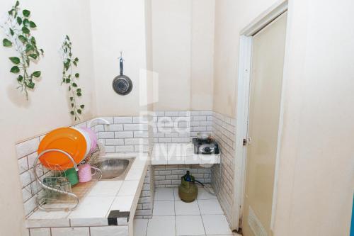 un pequeño baño de azulejos blancos con lavabo en RedLiving Apartemen Emerald Hill - SR Rooms Tower Green, en Karawang