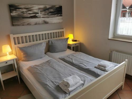 een slaapkamer met een bed met twee handdoeken erop bij FeWo Jadekieker mit Balkon - Horumersiel in Horumersiel