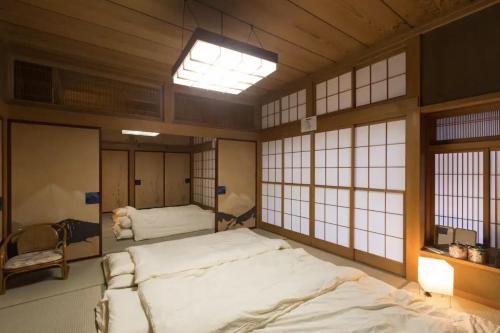 a bedroom with a large bed in a room with windows at Jokan-en in Honjo