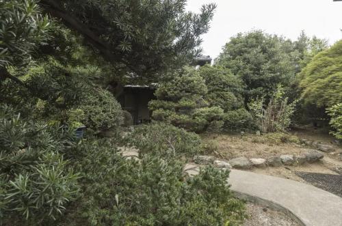 a garden with bushes and trees and a path at Jokan-en in Honjo