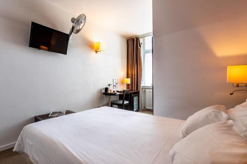 a hotel room with a white bed and a flat screen tv at Hôtel Le Mondon Metz in Metz