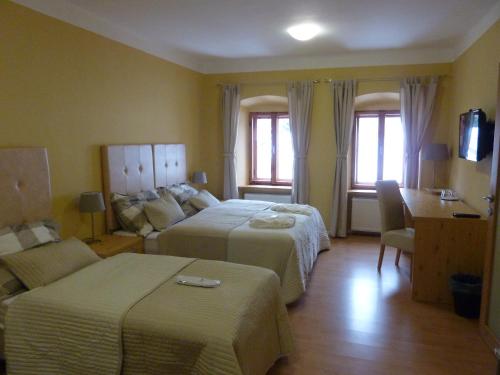 Habitación de hotel con 2 camas y sofá en Apartments and Suites Kremnica, en Kremnica