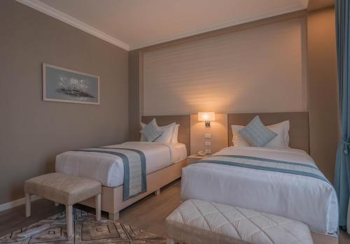 a bedroom with two beds and a chair in it at Haile Grand Addis Ababa in Addis Ababa