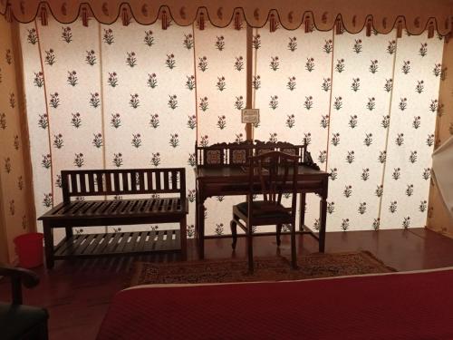 a room with a table and a chair and a desk at Hotel Green Haveli - A Heritage and Hill View Hotel , Pushkar in Pushkar