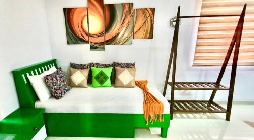 Un dormitorio con una cama verde y una silla en Hotel SU kataragama, en Kataragama