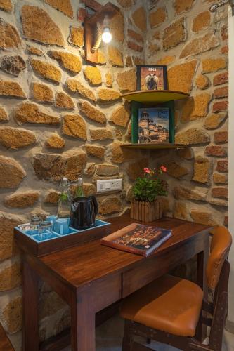 a wooden table in a room with a stone wall at SaffronStays Lake House Bouganvillea, Nashik - rustic pool villa with great lake views and patio dining in Nashik