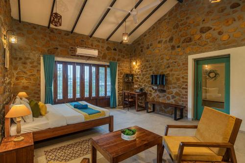 a bedroom with a bed and a living room at SaffronStays Lake House Bouganvillea, Nashik - rustic pool villa with great lake views and patio dining in Nashik
