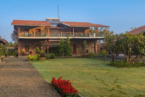 a large house with a large yard in front of it at SaffronStays Lake House Bouganvillea, Nashik - rustic pool villa with great lake views and patio dining in Nashik