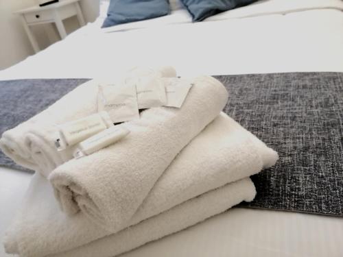 una pila de toallas sentadas encima de una cama en Modern Apartment 5 Minutes from Florence's Historic Center, en Florencia
