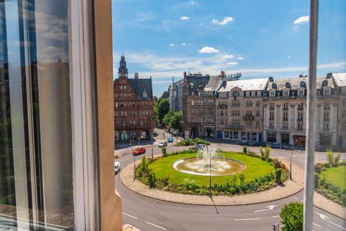 a view from a window of a city with a fountain at Hôtel Le Mondon Metz in Metz