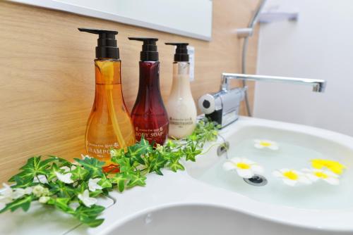 three bottles sitting on top of a bathroom sink at Hotel New Gaea Omuta Garden in Ōmuta