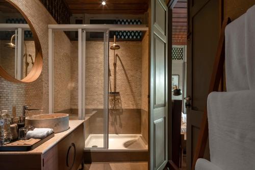 een badkamer met een douche, een wastafel en een bad bij neil niwas in Bangkok