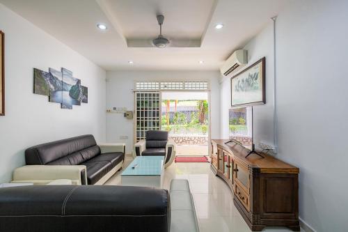 ein Wohnzimmer mit einem Sofa und einem Tisch in der Unterkunft Seaside Private Bungalow, Tg Bungah in Tanjung Bungah