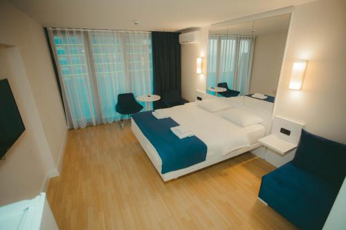 a hotel room with a large bed and a mirror at Come a Lot Aparthotel Batumi in Batumi