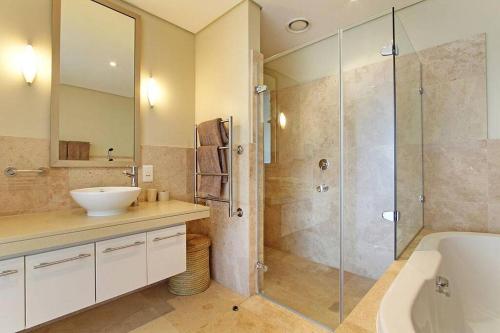 a bathroom with a sink and a glass shower at Luxury Villa in V&A Waterfront in Cape Town