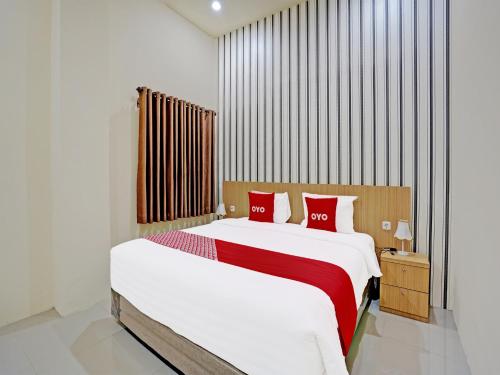 - une chambre avec un grand lit et des oreillers rouges dans l'établissement OYO 91997 Edhotel Smk Models Syariah, à Pasanggaran
