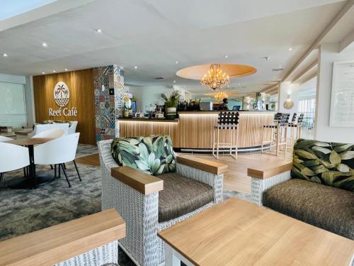 un restaurante con sofás y un bar en Breakers Resort Apartments en Durban