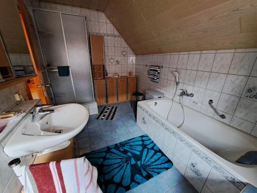ein Badezimmer mit einem Waschbecken und einer Badewanne in der Unterkunft Ferienwohnung Sonja mit Garten und Freisitz in Steinwiesen