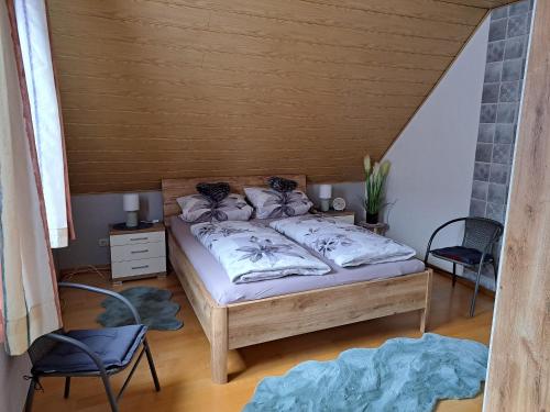 a bedroom with a bed and two chairs at Ferienwohnung Sonja mit Garten und Freisitz in Steinwiesen