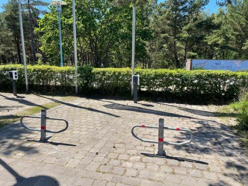 a park with two bike racks on a brick sidewalk at Aquamaris Strandresidenz Rügen in Juliusruh