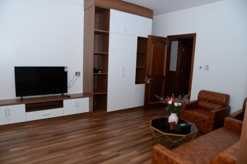 a living room with a couch and a tv at Hoang Hung Hotel in Dĩ An