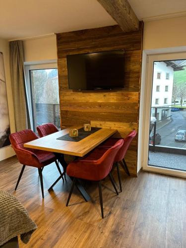 a dining room with a table and a flat screen tv at Appartments Das Franzal in Zell am Ziller