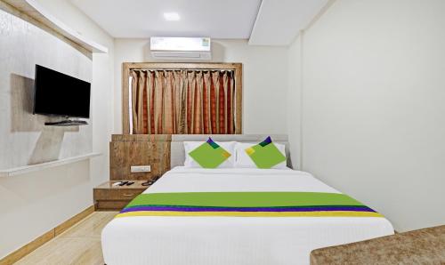 a bedroom with a large bed with a tv at Treebo Zion in Bengaluru