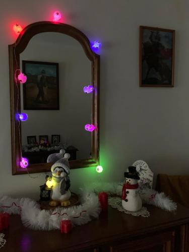 two snowmen are sitting on a table in front of a mirror at CASA LUI MOȘU in Alba Iulia