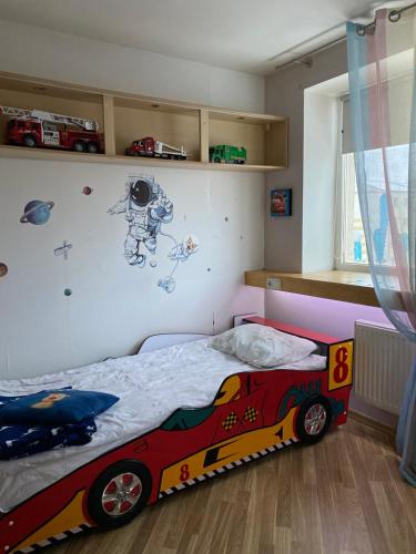 a bedroom with a bed with a race car mural on the wall at The Baltic coast apartment in Ventspils