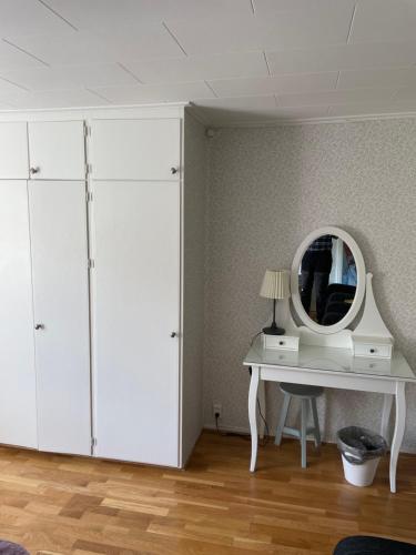 a room with a white desk and a mirror at Yaberg Affären in Hyltebruk
