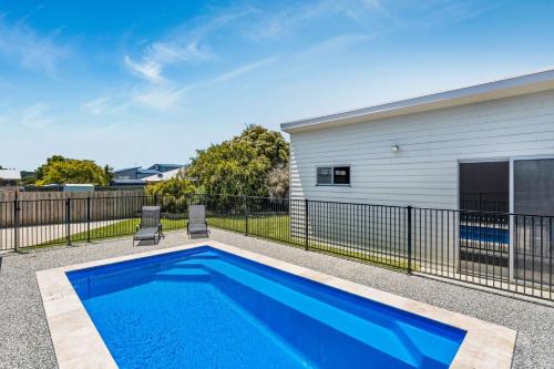 a swimming pool in front of a house at Bliss on Sanctuary in Cowes