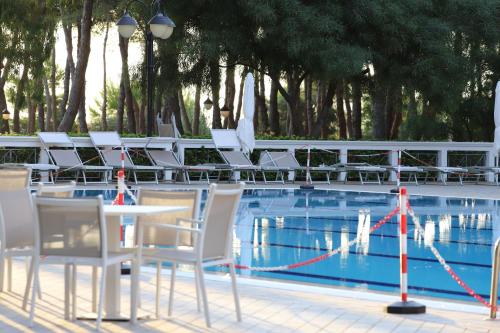 a table and chairs next to a swimming pool at Hotel Portonuovo in Vieste