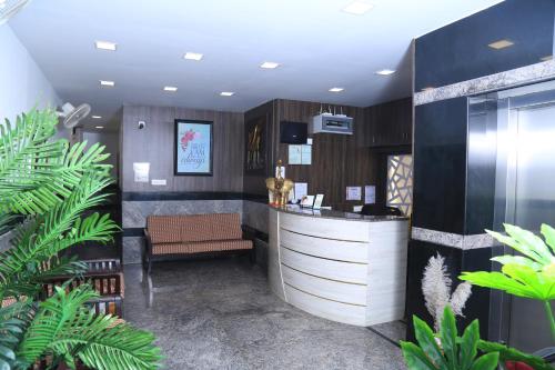 a lobby with a bar with a chair and plants at CHRISTIAN GUEST HOUSE in Vellore