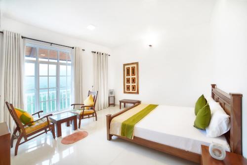 a bedroom with a bed and a large window at The Montfort, Nuwaraeliya in Nuwara Eliya