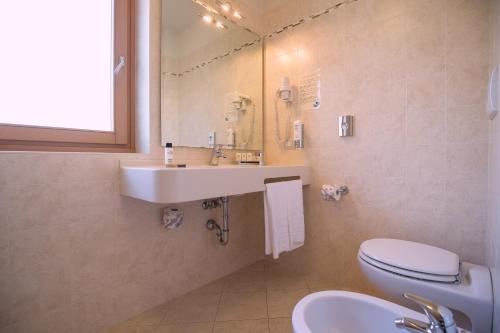 a bathroom with a sink and a toilet at Beverly Hotel in Pinzolo