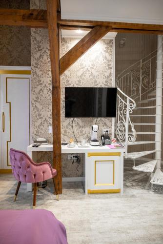 a bedroom with a desk and a pink chair at Queen Palace in Novi Sad