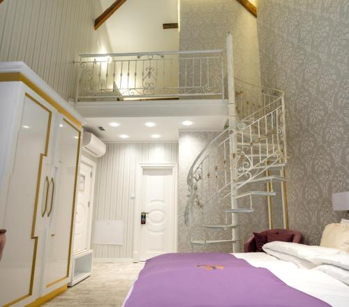 a bedroom with a purple bed and a spiral staircase at Queen Palace in Novi Sad