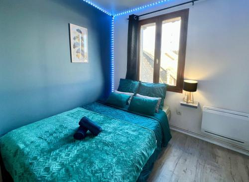 1 dormitorio con cama verde y ventana grande en La Feuille Dorée, Hyper-Centre, 15min Rouen, en Barentin
