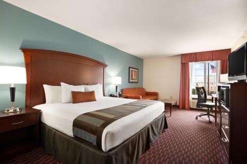a hotel room with a large bed and a desk at Wingate by Wyndham San Marcos in San Marcos