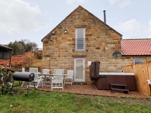 a brick house with a table and chairs in the yard at Meadowsweet in Whitby
